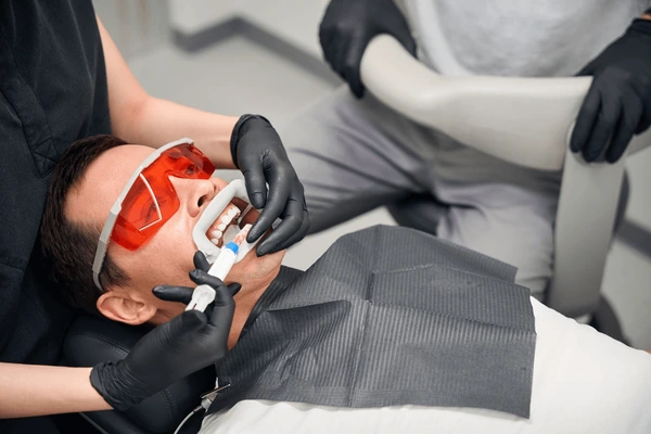 Dentist performing professional teeth whitening treatment at Triangle Dentistry in Raleigh, NC