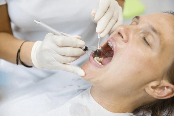 Dentist in Raleigh NC examining patient for early gum disease during routine dental checkup